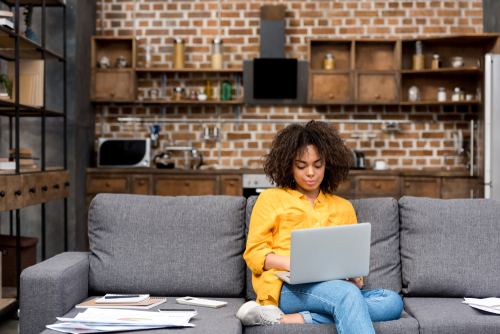 Attractive,Young,Woman,Working,Working,With,Laptop,On,Couch