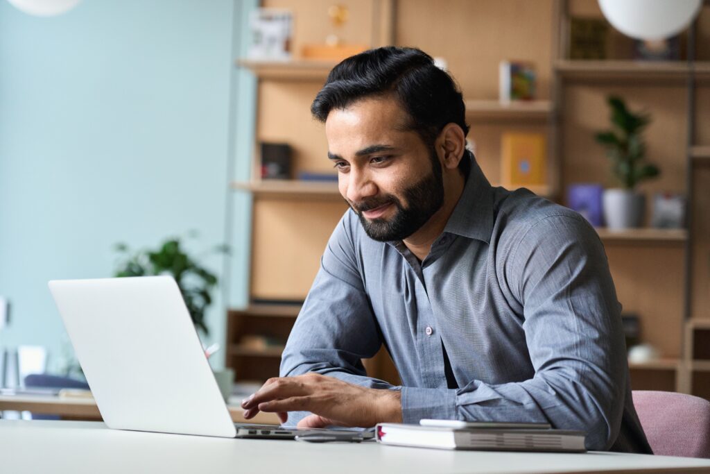 Smiling,Indian,Business,Man,Working,On,Laptop,At,Home,Office.