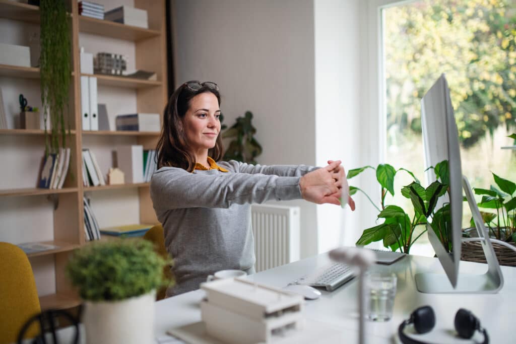 Attractive,Businesswoman,Sitting,Indoors,In,Office,,Stretching.