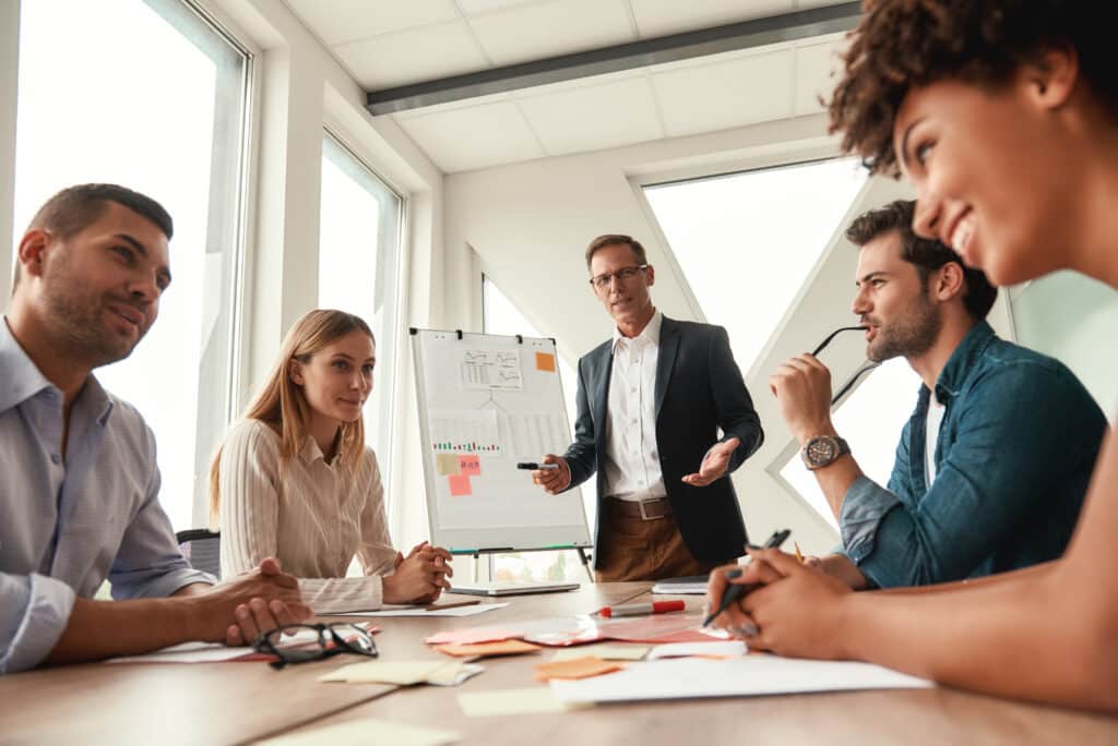 Working,Together.,Mature,Businessman,In,Formal,Wear,Standing,Near,Whiteboard