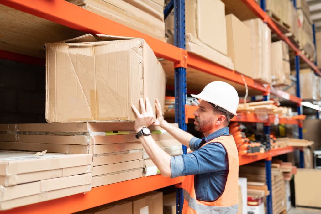 Side,View,Of,Attractive,Male,Employee,Positioning,Cardboard,Box,In