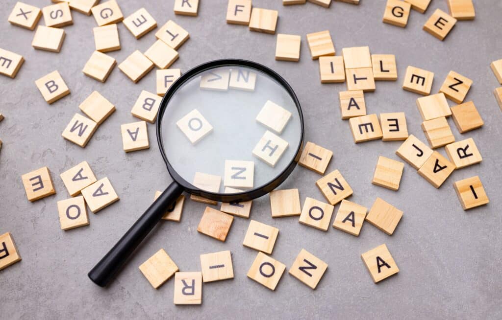 Square,Letter,Tiles,With,Magnifying,Glass,Against,Blue,Background.,Search