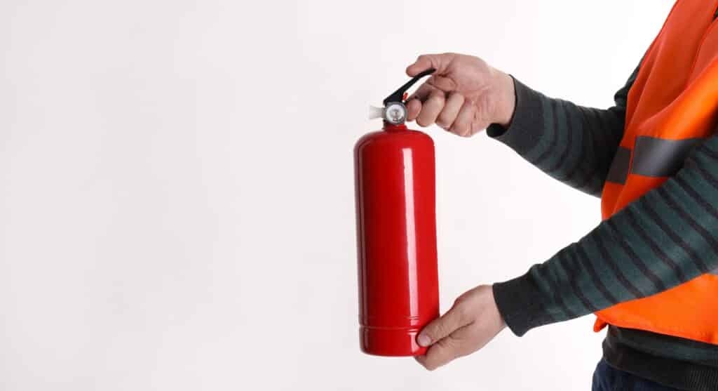 Man,With,Fire,Extinguisher,On,Light,Background,,Closeup.,Space,For